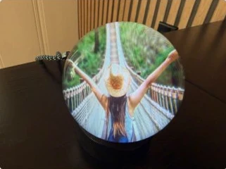 Memory Orb on a stand showing a travel photo on a rope bridge
