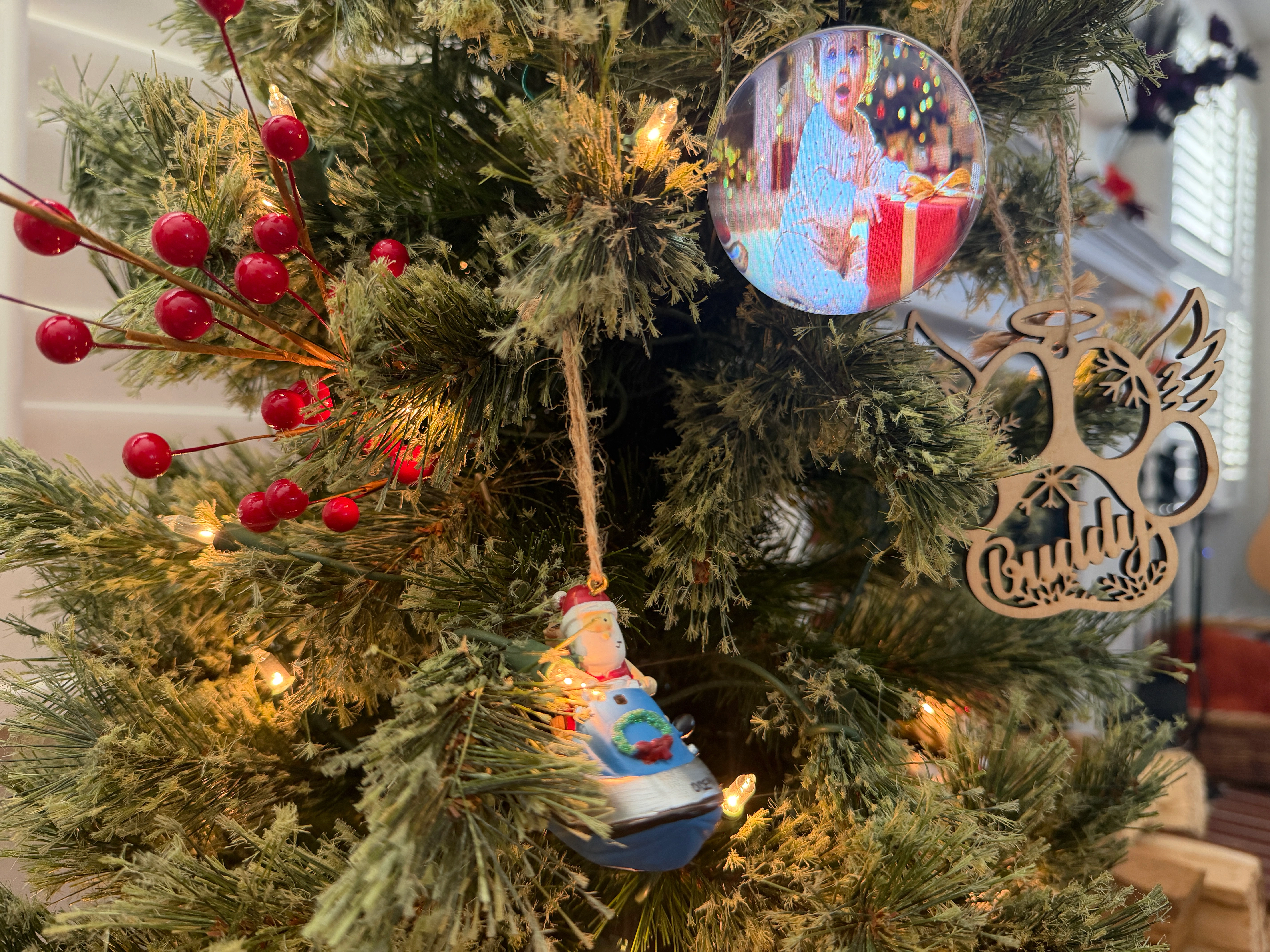Memory Orb hanging among red berries on a decorated Christmas tree